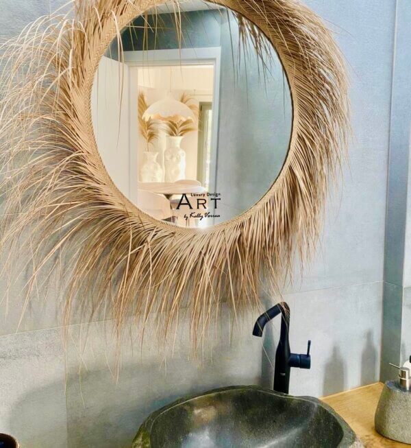 Luxury bathroom with stone washbasin and palm round mirror.